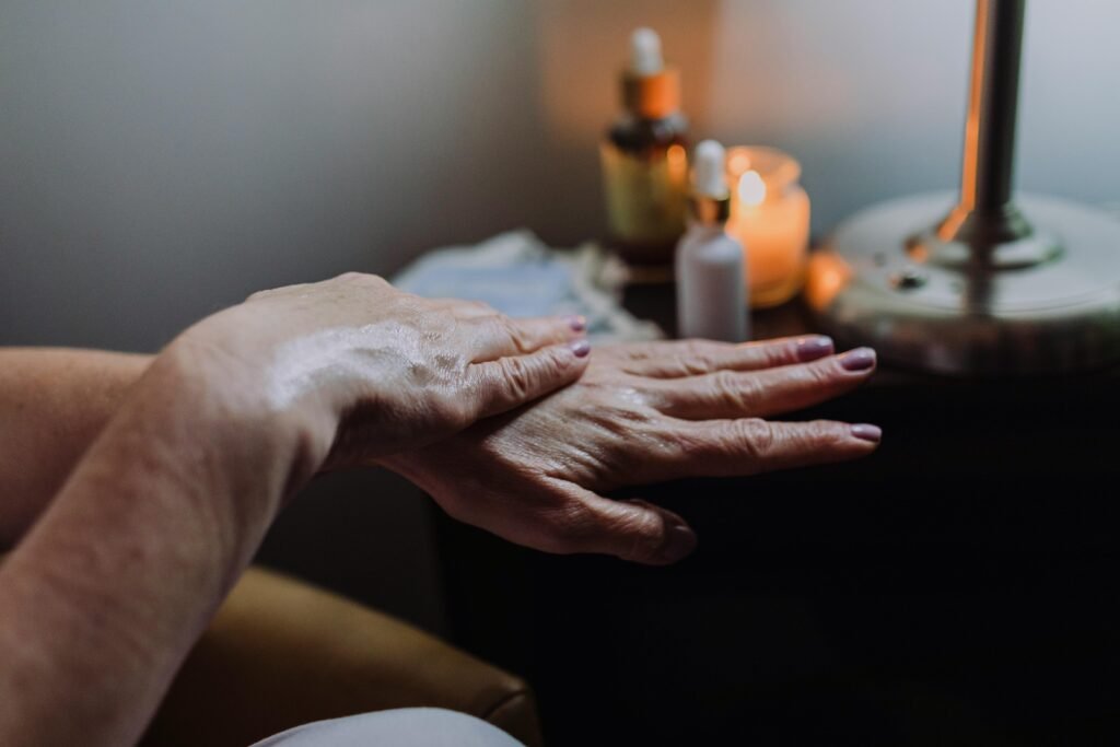 Hand care with lotion in a soothing spa ambiance, featuring candles and relaxation elements.